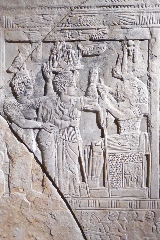 A stone carving of people in a room
Description automatically generated